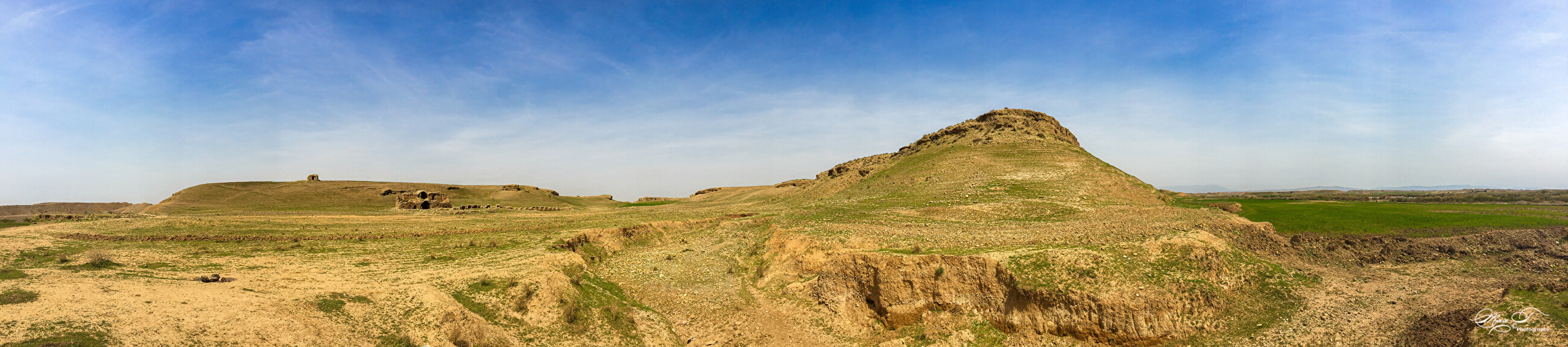 Panoramic landscape of the ruins of Mahmud Pasha al-Jaf Palace near Tazade village in Iraqi Kurdistan, with arid hills, ancient stone structures, and blue sky